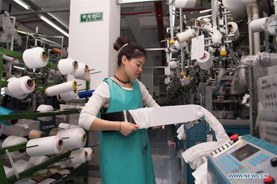 A worker checks on fabric quality at a sock company in Datang community of Zhuji, east China's Zhejiang Province, Oct. 27, 2020. Sock companies in Datang, a major sock manufacturing base, began to see a rebound in business in the second half of the year. (Xinhua/Sadat)