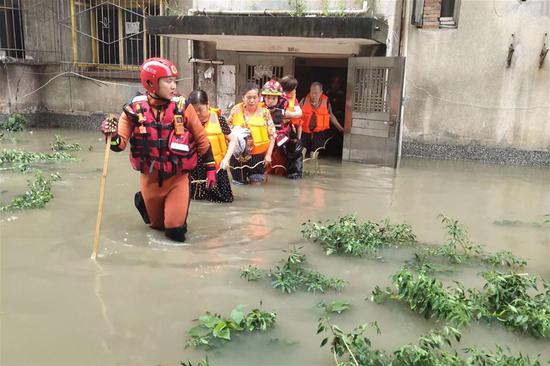 Rescuers help evacuate trapped people in Guanghan City, southwest China's Sichuan Province, Aug. 12, 2020. Heavy rain is continuing to wreak havoc in Sichuan Province, with tens of thousands of residents evacuated, houses damaged and roads blocked. Torrential rain starting from Monday evening in the province has left six people dead and five others missing, and has forced more than 40,000 residents to evacuate as of Wednesday noon, according to the province's flood control and drought relief headquarters. Around 107,000 people had been affected by the rain across the province, with 14 rivers swollen by floodwater, it said. (Xinhua)